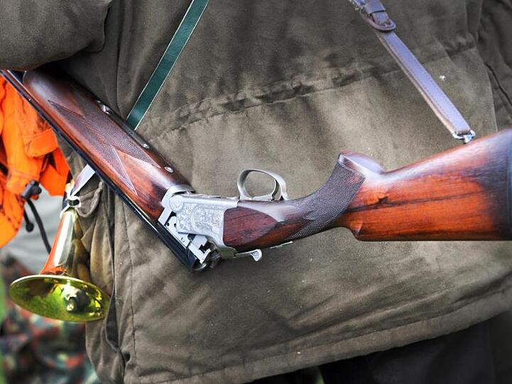 Ein Jäger hat sein geöffnetes Jagdgewehr um die Schulter hängen. Foto: dpa/Archivbild