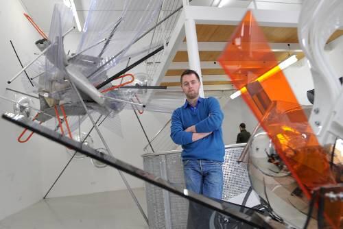 Eingefrorene Teilchen-Beschleunigung: Sebastian Kuhn in der Kreis-Galerie &ndash; mit seinem Kolossal-Objekt &bdquo;Torque&ldquo; im Hintergrund.