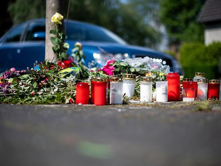 Blumen und Kerzen stehen an der Unfallstelle.