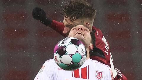 Tim Latteier (hinten) vom 1. FC Nürnberg und Andreas Albers von Jahn Regensburg kämpfen um den Ball.