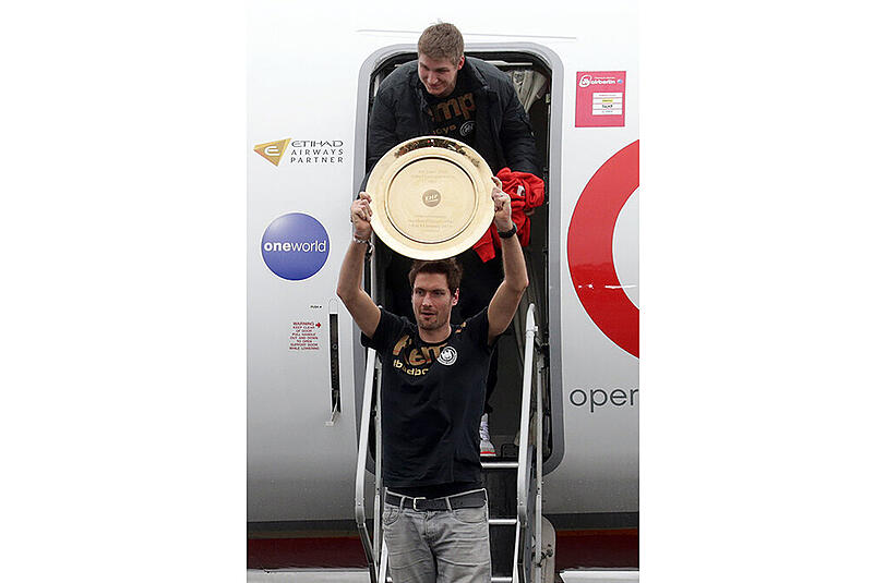 Da ist das Ding! Der deutsche Handball-Nationaltorwart Carsten Lichtlein präsentiert den "Teller" bei der Ankunft in Berlin.