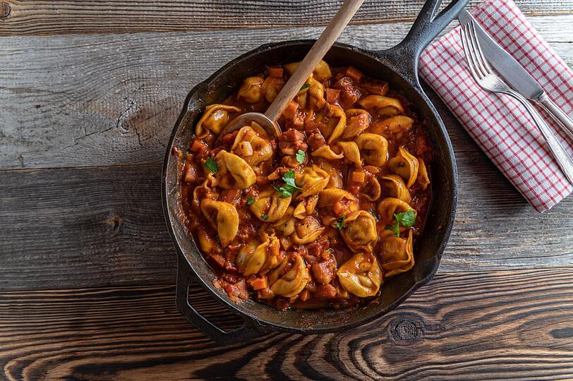 Anschließend geben Sie 600 Gramm frische Tortellini - etwa mit Ricotta-Spinat-Füllung - direkt in den Topf. Gießen Sie 200 Milliliter Sahne und 250 Milliliter Gemüse- oder Hühnerbrühe hinzu, sodass die Nudeln gerade so damit bedeckt sind. Dann alles mit einem Teelöffel italienischer Kräuter, einem halben Teelöffel Chiliflocken sowie Salz und schwarzen Pfeffer würzen. Anschließend geben Sie 600 Gramm frische Tortellini - etwa mit Ricotta-Spinat-Füllung - direkt in den Topf. Gießen Sie 200 Milliliter Sahne und 250 Milliliter Gemüse- oder Hühnerbrühe hinzu, sodass die Nudeln gerade so damit bedeckt sind. Dann alles mit einem Teelöffel italienischer Kräuter, einem halben Teelöffel Chiliflocken sowie Salz und schwarzen Pfeffer würzen.
