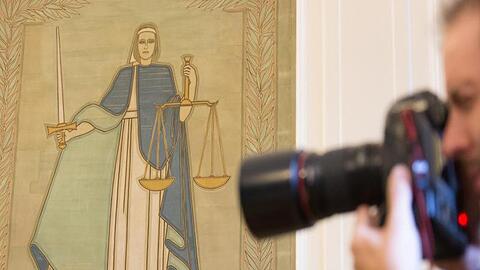Ein Fotograf vor dem Bild der Justitia. Foto: Friso Gentsch/Archivbild