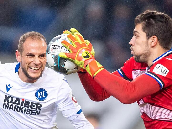 Bielefelds Torwart Stefan Ortega (r) schnappt sich den Ball vor KSC-Spieler Manuel Stiefler.