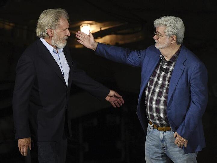 George Lucas (r) begrüßt Harrison Ford bei der Eröffnungsfeier des "Star Wars: Galaxy's Edge"-Themenparks.