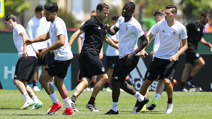 DFB-Teamanager Oliver Bierhoff (Mitte) nimmt während des Confed Cups in Sotschi am Aufwärmtraining der Nationalmannschaft teil. Links im Bild Neu-Bayer Sebastian Rudy.