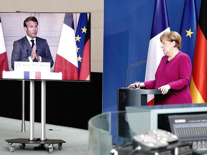Bundeskanzlerin Merkel und Emmanuel Macron bei einer Pressekonferenz. Frankreichs Präsident ist per Video zugeschaltet.