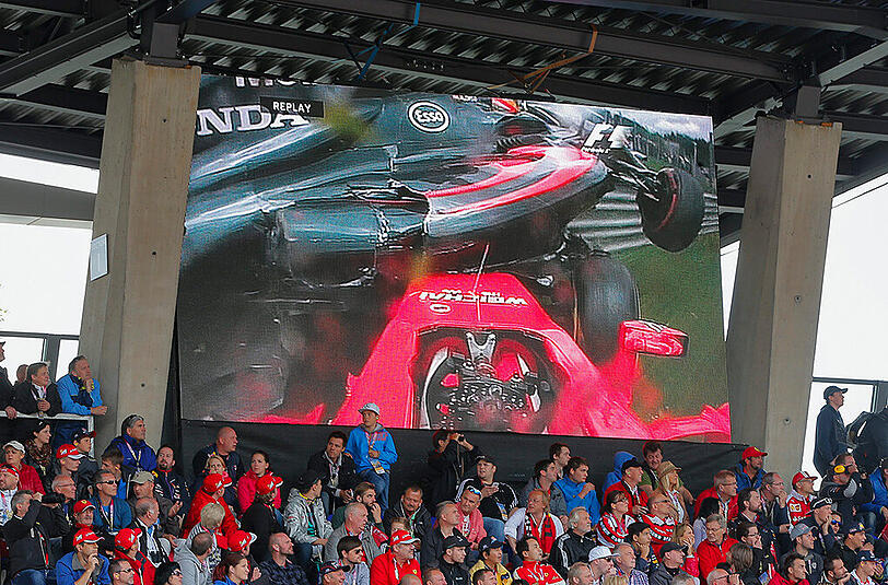 Auf einem Bildschirm ist die Onboard-Kamera von Räikkönen zu sehen. Alonsos McLaren verfehlte den Schweden nur knapp.