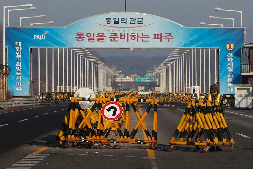 Ein Arbeiter schiebt Barrikaden vor die Einfahrt zur Straße nach Nordkorea. Die gemeinsame Wirtschaftszone Kaseong ist der einzige Ort, wo Nord- und Südkoreaner zusammen arbeiten.