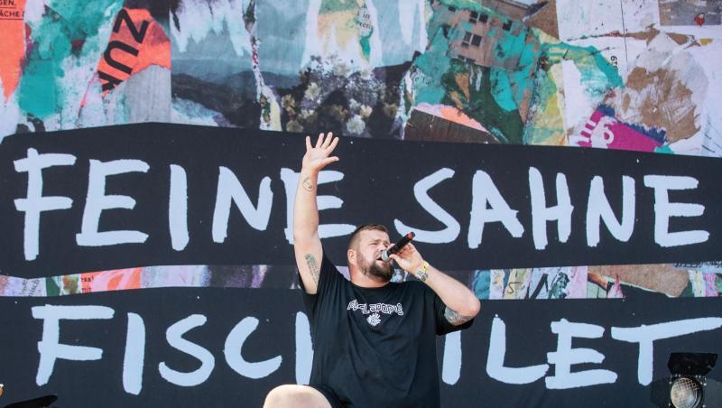 Jan "Monchi" Gorkow (M.), Sänger der deutschen Punkband "Feine Sahne Fischfilet", steht auf der Bühne und singt. Foto: Daniel Karmann Jan "Monchi" Gorkow (M.), Sänger der deutschen Punkband "Feine Sahne Fischfilet", steht auf der Bühne und singt. Foto: Daniel Karmann