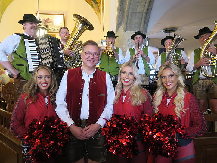 Wirt Wolfgang Sperger mit US-Cheerleadern der Buccaneers und Musikern des bayerischen Ballast-Orchesters.
