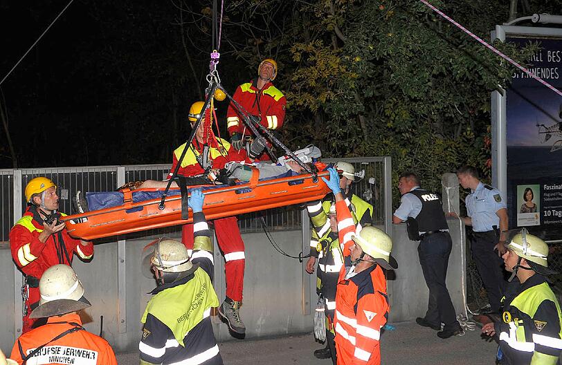 Höhenretter der Feuerwehr bergen mit einem Spezialkorb den verletzten Schweizer nach seinem Sturz an der Friedenheimerbrücke.