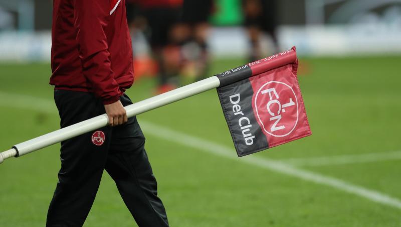 Ein Helfer trägt eine Eckfahne mit dem Logo des 1. FC Nürnberg. Foto: Daniel Karmann/Archiv Ein Helfer trägt eine Eckfahne mit dem Logo des 1. FC Nürnberg. Foto: Daniel Karmann/Archiv