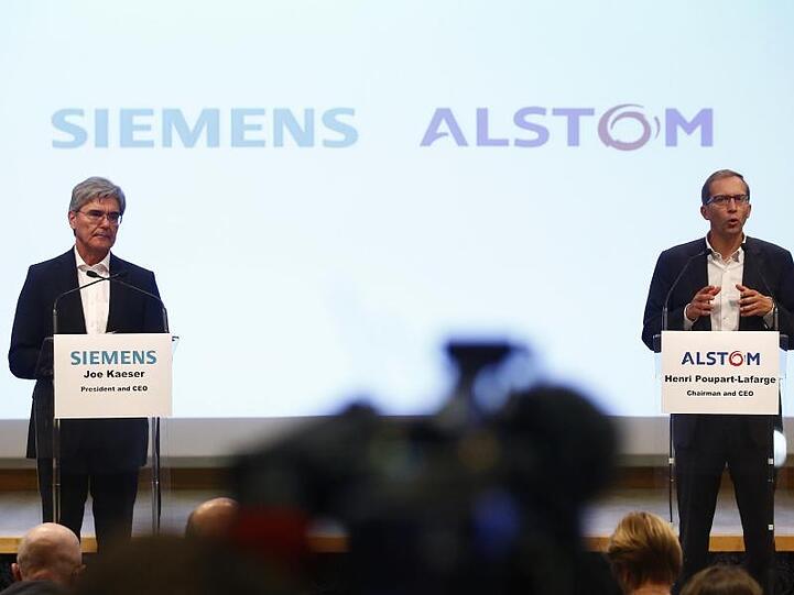 Alstom-CEO Henri Poupart-Lafarge (r), und der Vorstandsvorsitzende von Siemens, Joe Kaeser, sprechen. Foto: Thibault Camus/AP/Archiv
