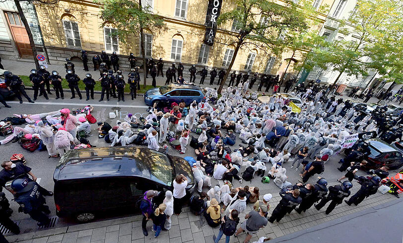 Demonstranten haben sich in der Karlstraße versammelt – gut bewacht von der Polizei.