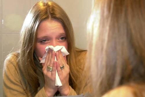 Sie hat es schon erwischt: Eine junge Frau leidet unter den typischen Grippesymptomen