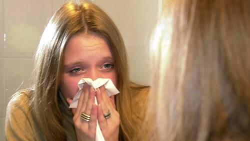 Sie hat es schon erwischt: Eine junge Frau leidet unter den typischen Grippesymptomen Sie hat es schon erwischt: Eine junge Frau leidet unter den typischen Grippesymptomen