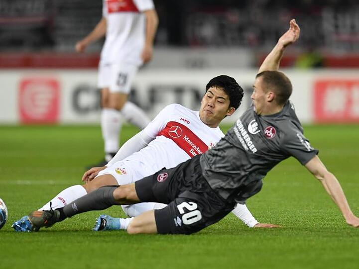 Stuttgarts Wataru Endo spielt gegen Nürnbergs Lukas Jäger (r). Foto: Thomas Kienzle/dpa
