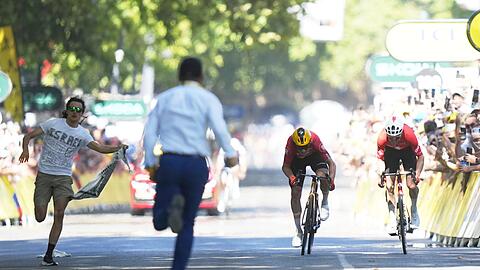 Während Jonas Abrahamsen und Mauro Schmid (r) in Toulouse um den Sieg sprinten, läuft ein Flitzer (l) auf die Zielgerade.