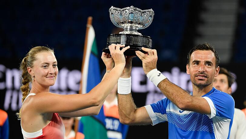 Kristina Mladenovic und Ivan Dodig halten ihre Trophäe nach ihrem Sieg in die Höhe.