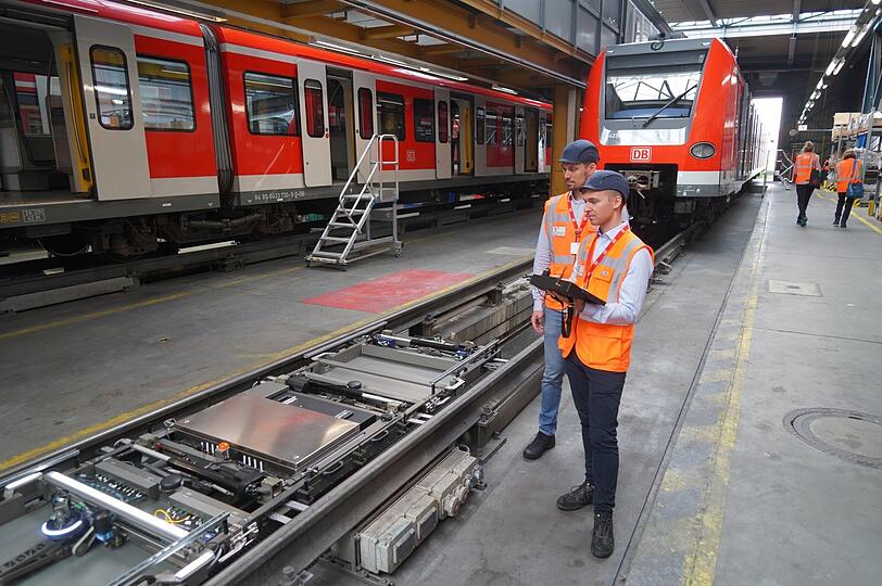 Das da in den Schienen ist ein Roboter, der die S-Bahn von unten auf Schäden hin kontrollieren soll. Zum Beispiel stellt er fest, ob alle Schrauben fest sind. Bahn-Mitarbeiter können ihn mit einem Tablett steuern.