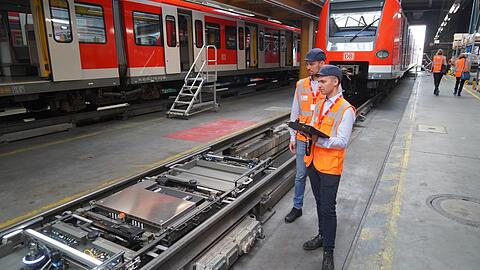 Das da in den Schienen ist ein Roboter, der die S-Bahn von unten auf Schäden hin kontrollieren soll. Zum Beispiel stellt er fest, ob alle Schrauben fest sind. Bahn-Mitarbeiter können ihn mit einem Tablett steuern.