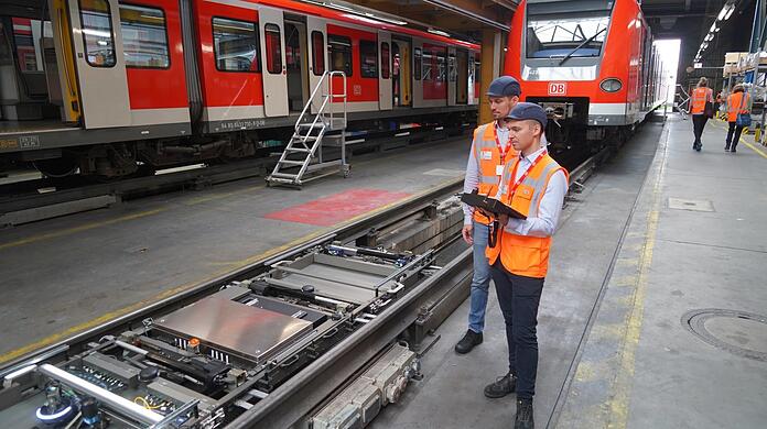 Das da in den Schienen ist ein Roboter, der die S-Bahn von unten auf Schäden hin kontrollieren soll. Zum Beispiel stellt er fest, ob alle Schrauben fest sind. Bahn-Mitarbeiter können ihn mit einem Tablett steuern.