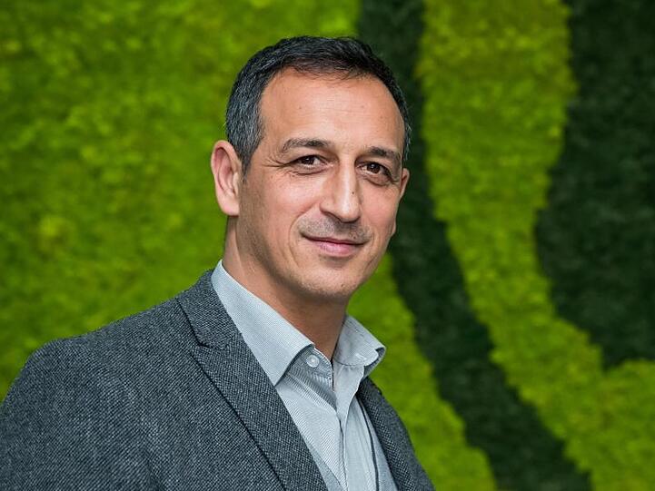 Rachid Azzouzi lächelt im Profil stehend. Foto: Daniel Karmann/dpa