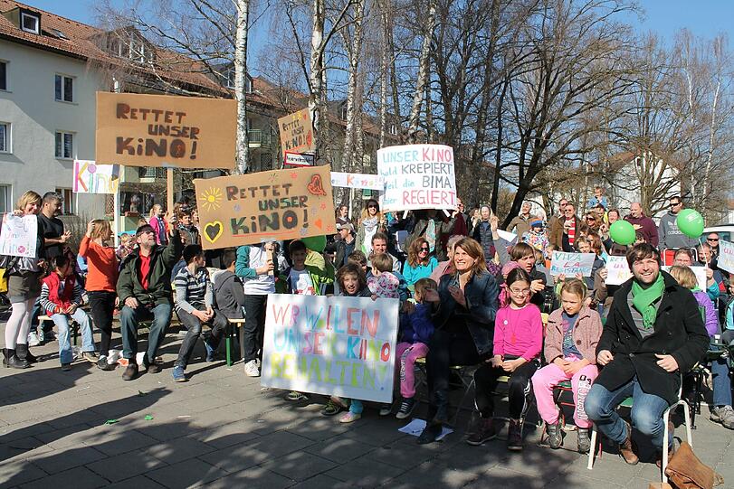 Vor dem Cincinnati Kino haben sich Kinder und Erwachsene zum Sitzstreik aufgebaut. Die Parole: "Unser Kino soll bleiben".