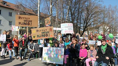 Vor dem Cincinnati Kino haben sich Kinder und Erwachsene zum Sitzstreik aufgebaut. Die Parole: "Unser Kino soll bleiben".