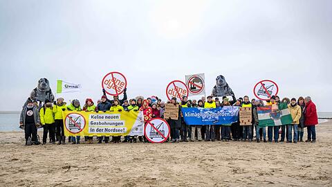 Umweltschützer und Insulaner demonstrieren am Weststrand von Borkum mit Bannern und Plakaten gegen die geplante Erdgasförderung.