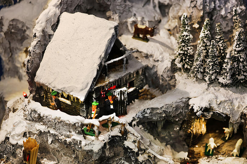 Detail aus einer Schneekrippe mit Figuren aus Berchtesgaden, die auch Brauchtum aus der Region zeigt.