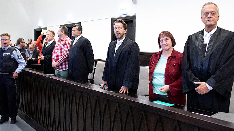 Der Angeklagte Wilfried Max W. (5.v.r.) steht neben seinen Verteidigern Carsten Ernst (6.v.r.) und Detlev Binder (4.v.r.) in einem Saal des Landgerichts. Rechts daneben steht die Angeklagte Angelika W. (2.v.r.) neben ihrem Anwalt Peter Wüller (r.).