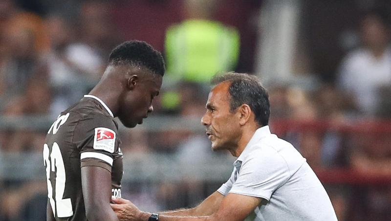 St. Paulis Trainer Jos Luhukay spricht mit Christian Conteh (l) am Spielfeldrand. Foto: Christian Charisius/dpa St. Paulis Trainer Jos Luhukay spricht mit Christian Conteh (l) am Spielfeldrand. Foto: Christian Charisius/dpa