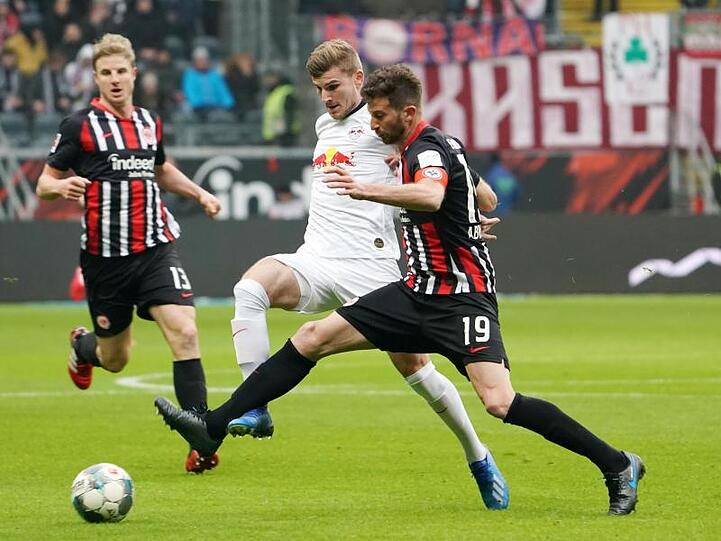 Leipzigs Timo Werner (M) kämpft mit Frankfurts David Abraham (r) um den Ball.