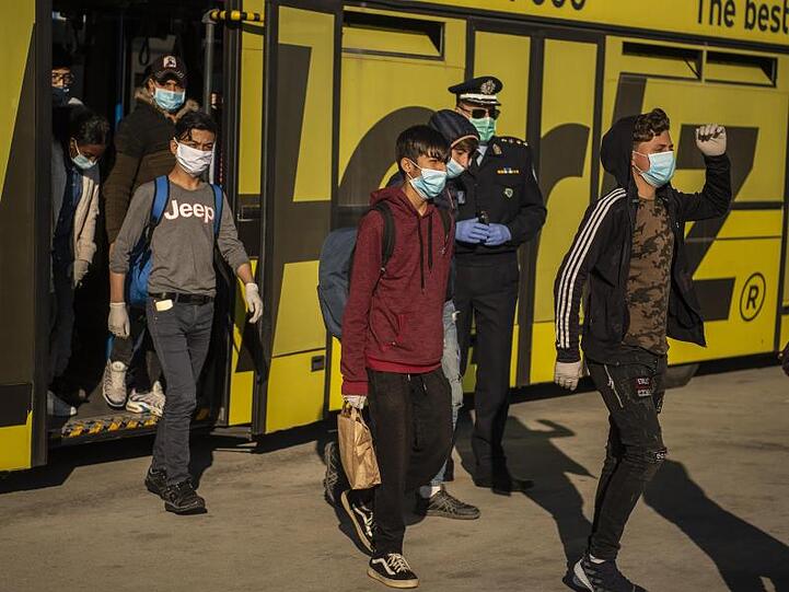 Minderjährige Flüchtlinge von griechischen Inseln gehen am Athener Flughafen zu einem Flugzeug, das sie nach Hannover bringen soll.