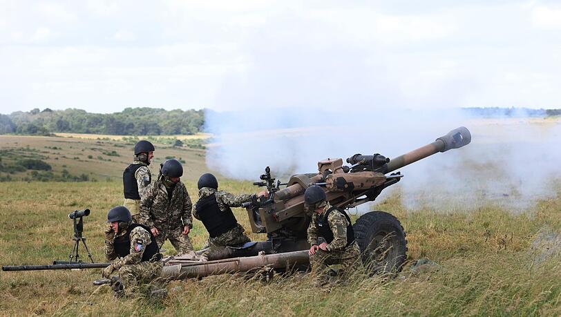Britische Soldaten bilden Angehörige der ukrainischen Streitkräfte in der Bedienung leichter Geschütze vom Typ L119 aus.