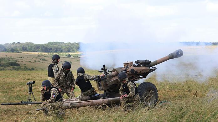 Britische Soldaten bilden Angehörige der ukrainischen Streitkräfte in der Bedienung leichter Geschütze vom Typ L119 aus.