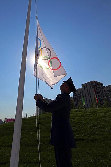 Ein britischer Soldat hisst die olympische Flagge während einer Begrüßungszeremonie im Olympischen Dorf
