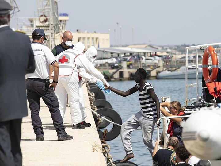 Migranten verlassen im Hafen von Pozzallo auf Sizilien das deutsche Rettungsschiff Eleonore.