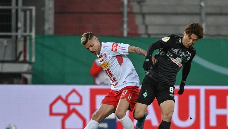 Regensburgs Jan Elvedi und Bremens Yuya Osako (r) kämpfen um den Ball.