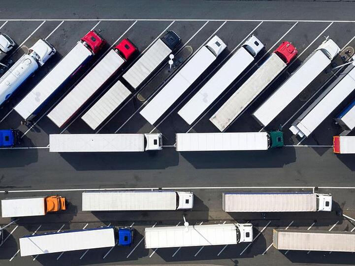 Blick aus der Luft auf abgestellte Lastwagen auf einer Rastätte.