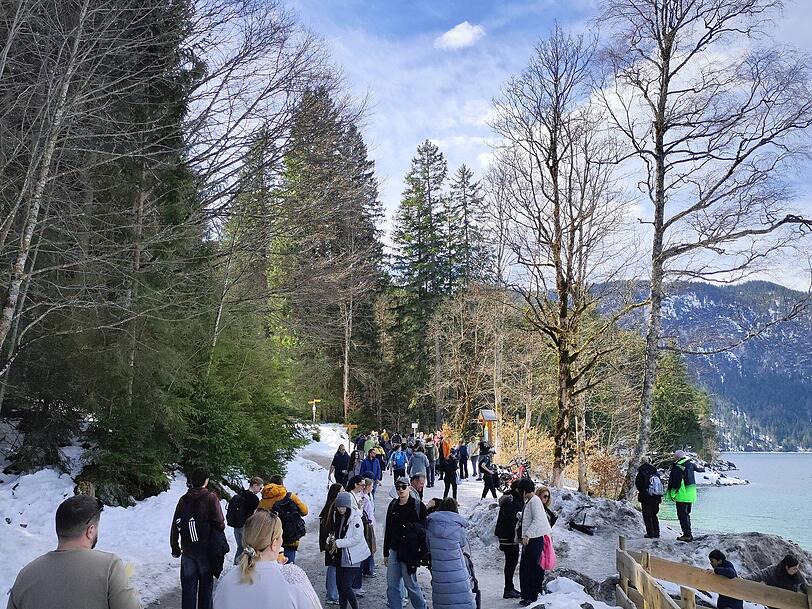 Menschen str&ouml;men zum Eibsee. Dessen teils t&uuml;rkises Wasser erinnert so manchen Besucher an die Karibik.