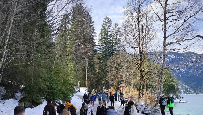 Menschen str&ouml;men zum Eibsee. Dessen teils t&uuml;rkises Wasser erinnert so manchen Besucher an die Karibik.