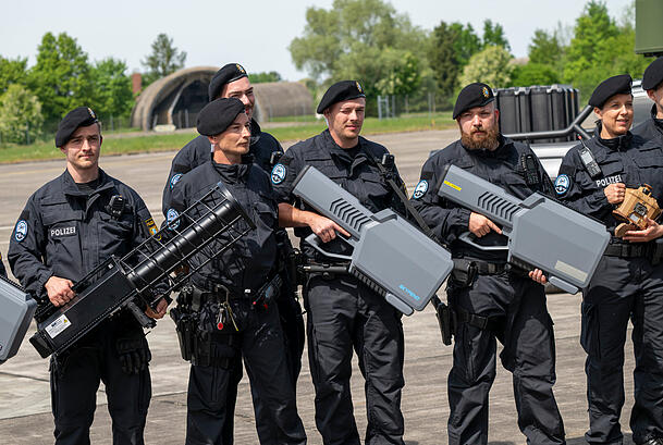 Polizisten halten während der Eröffnung des Drohnenkompetenz- und -abwehrzentrum diverse Drohen-Abfanggeräte in den Händen. Polizisten halten während der Eröffnung des Drohnenkompetenz- und -abwehrzentrum diverse Drohen-Abfanggeräte in den Händen.