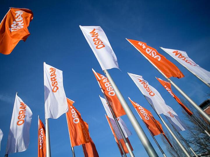 Flaggen mit dem Logo von Osram wehen im Wind. Foto: Matthias Balk/Archiv