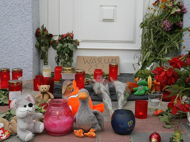 Kerzen, Blumen und Stofftiere erinnern vor dem Haus in Ludwigshafen an die Opfer des Familiendramas.