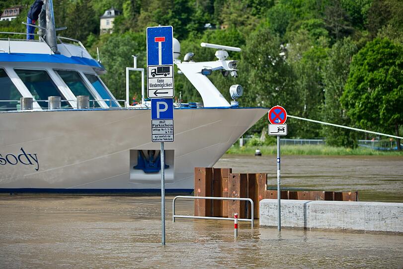 Schilder eines Parkplatzes stehen in Würzburg vor einem Schiff in den Fluten des Main-Hochwassers.