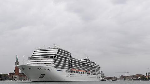 Ein Kreuzfahrtschiff fährt an der Lagunenstadt Venedig von einem Schlepper gezogen vorbei.