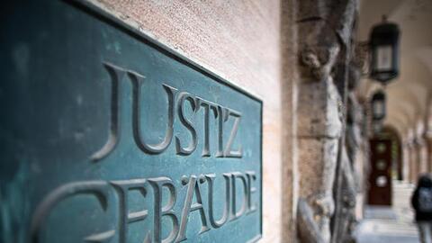Ein Schild mit der Aufschrift "Justizgebäude" hängt am Eingang am Landgericht Nürnberg-Fürth. Foto: Daniel Karmann/dpa/Archivbild